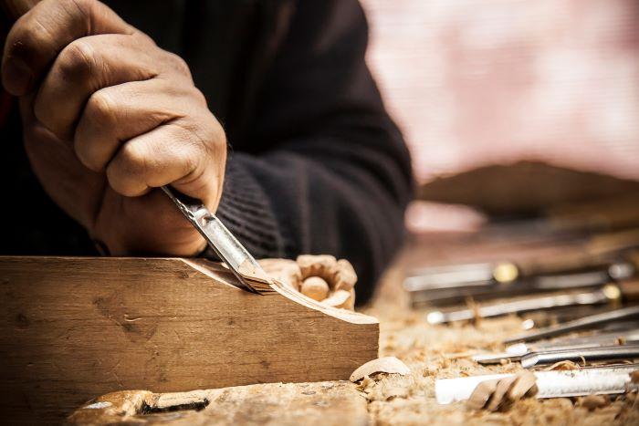A person using a chisel to carve wood
