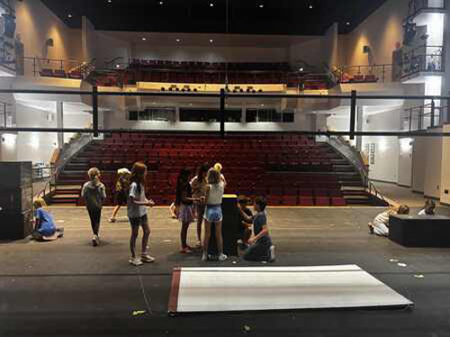 Several kids gathered on a stage