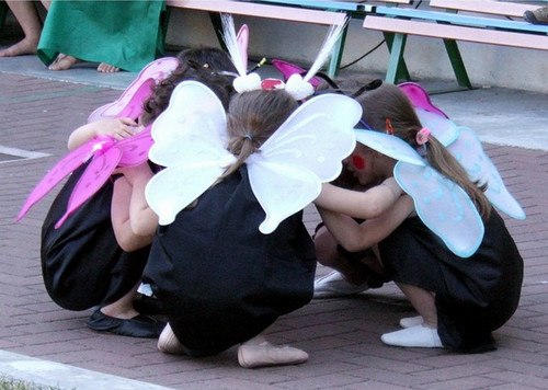 Group of kids gathered in a circle wearing butterfly wings
