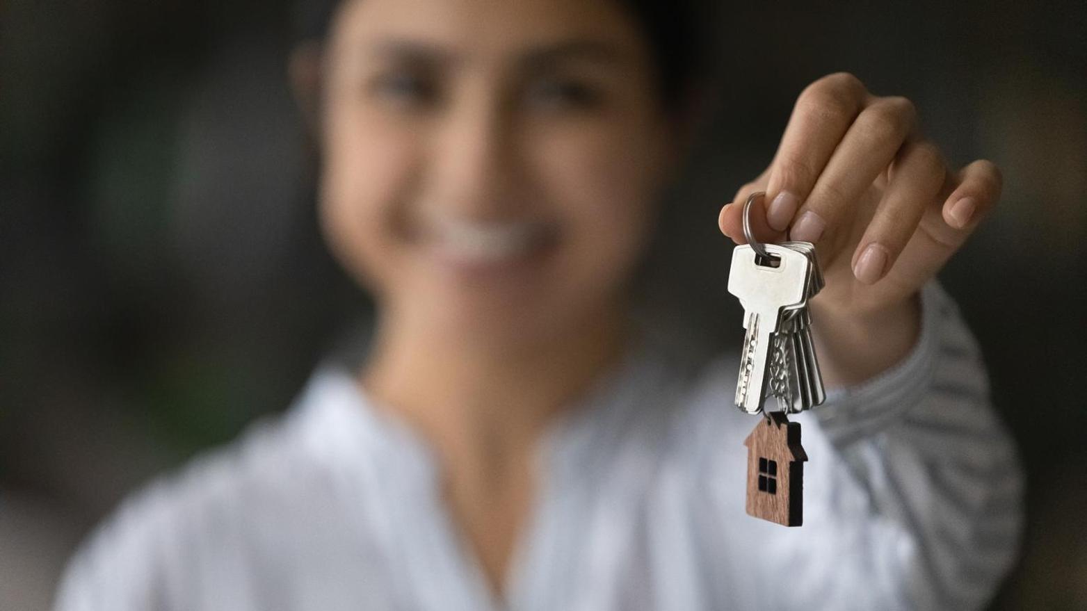 Woman handing you keys to a house