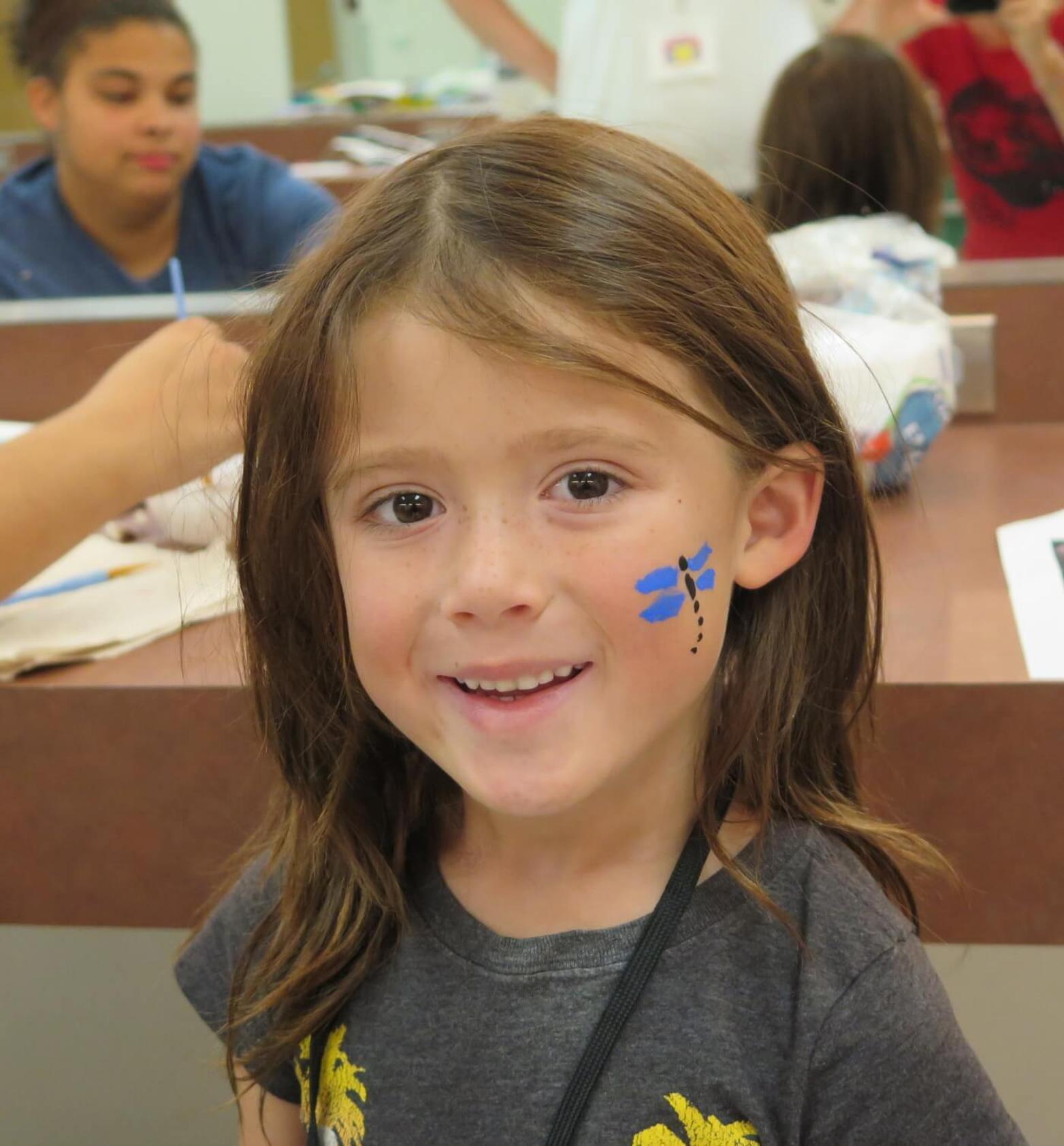 smiling girl with a butterfly painted on her face