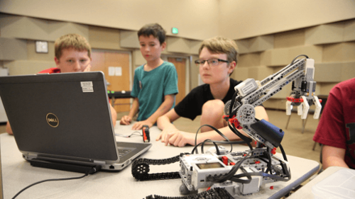 children building a lego robot arm